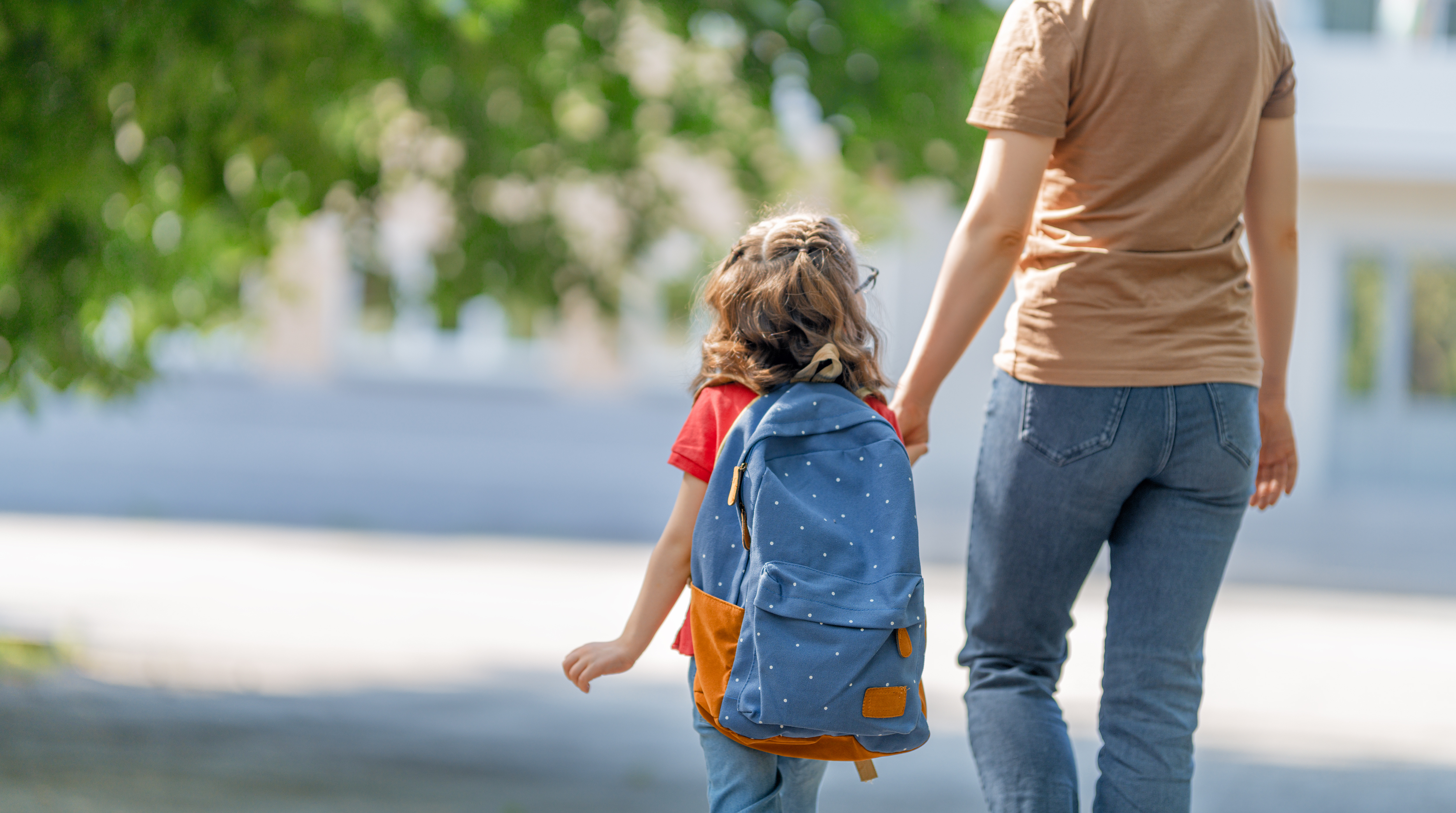 A Woman walking with a child through a outdoor urban setting