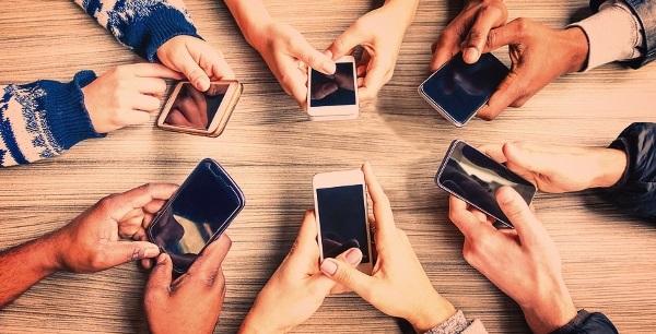 Circle of people holding phones in their hands